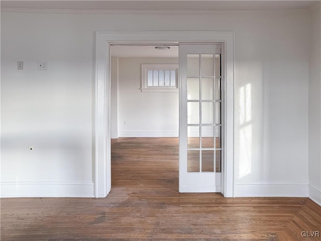 empty room with wood-type flooring, crown molding, and french doors