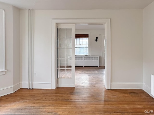 hall featuring light wood-type flooring and radiator heating unit