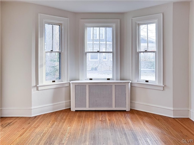 spare room with radiator and light hardwood / wood-style floors