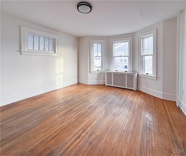 spare room featuring radiator and light wood-type flooring