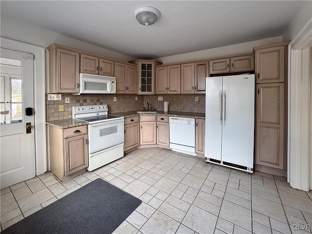 kitchen featuring white appliances, sink, decorative backsplash, dark stone countertops, and light tile patterned flooring