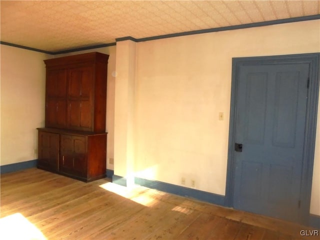 spare room with crown molding and light hardwood / wood-style flooring