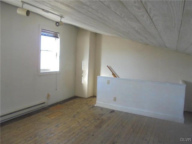 additional living space with dark hardwood / wood-style flooring, a baseboard radiator, and wooden ceiling