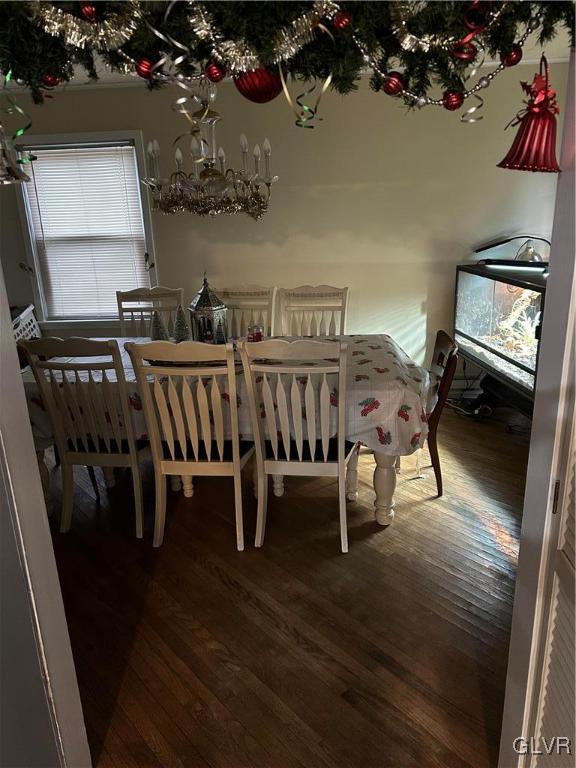 dining room with hardwood / wood-style floors and a chandelier