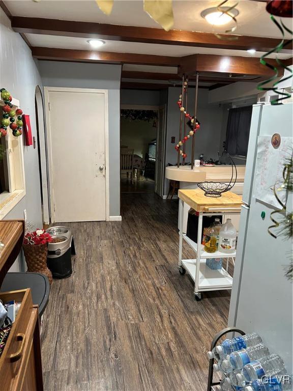 basement with white refrigerator and dark wood-type flooring