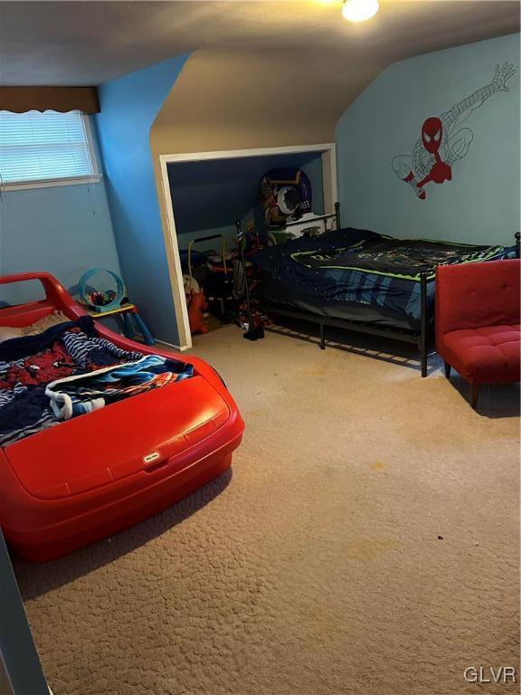 bedroom with carpet and lofted ceiling