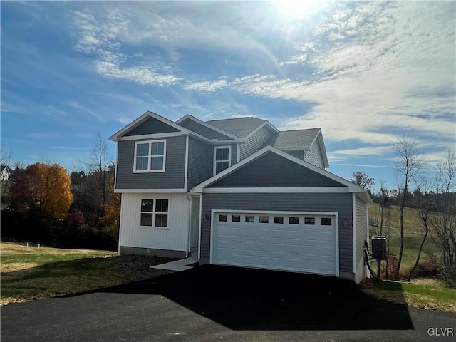 view of front of home featuring central air condition unit and a garage