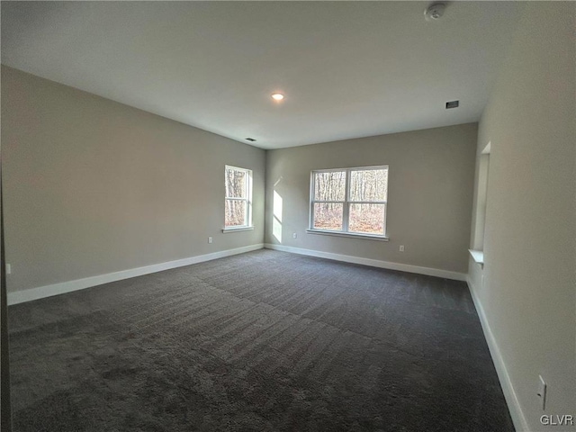 unfurnished room with dark carpet