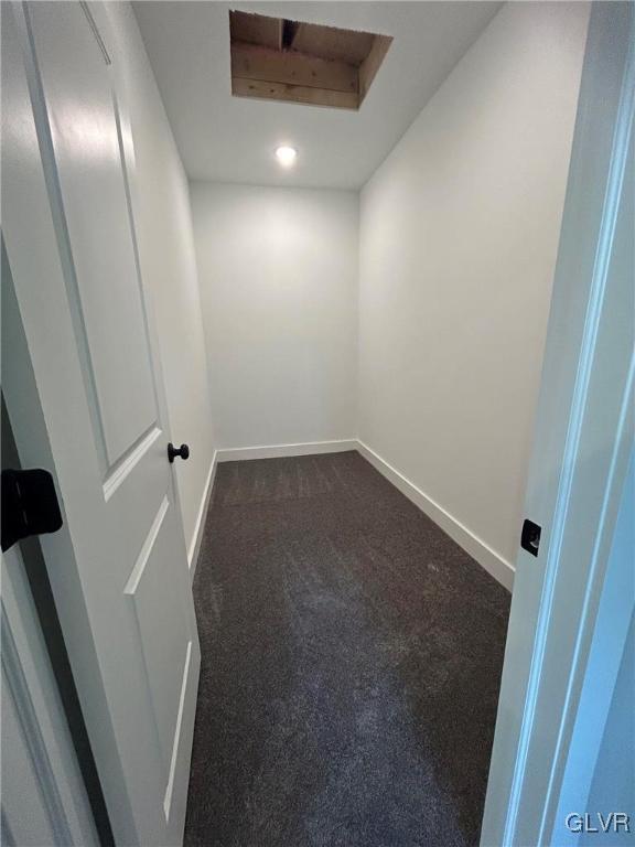 unfurnished room featuring dark carpet