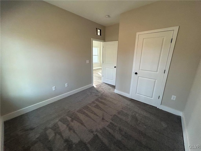 unfurnished bedroom with dark carpet