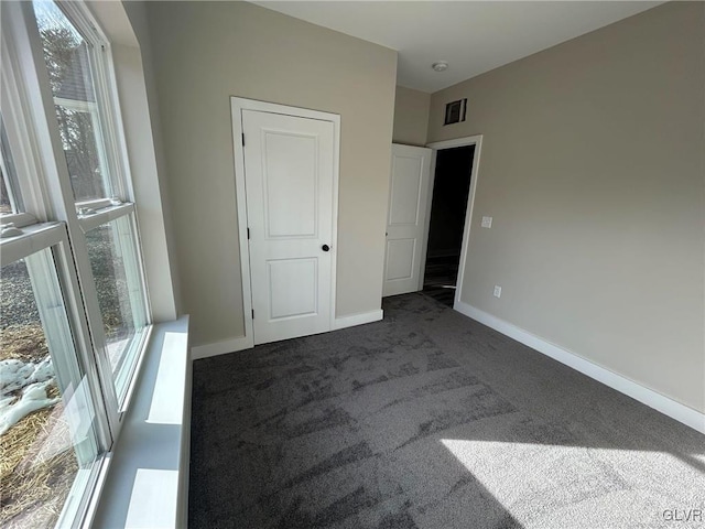 unfurnished bedroom featuring carpet, a closet, and multiple windows