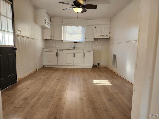 kitchen with white cabinets, light hardwood / wood-style floors, and a wealth of natural light