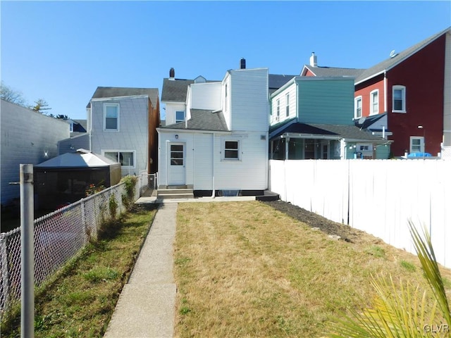 back of house featuring a gazebo and a lawn