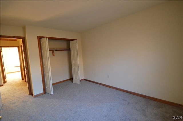 unfurnished bedroom featuring light carpet and a closet