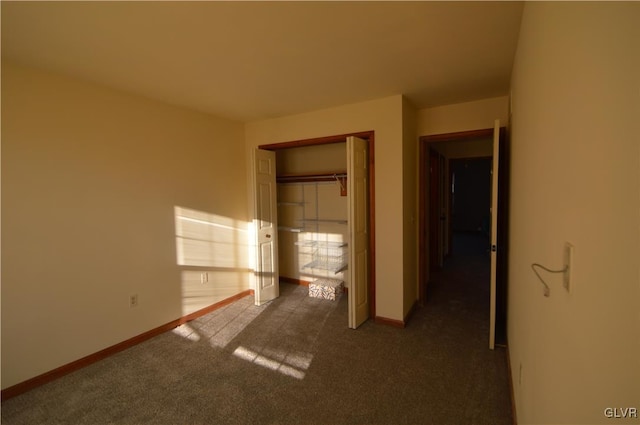 unfurnished bedroom with a closet and dark colored carpet