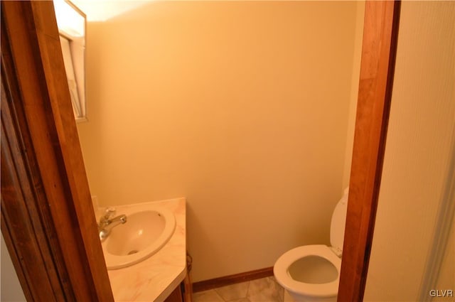 bathroom with toilet, vanity, and tile patterned floors