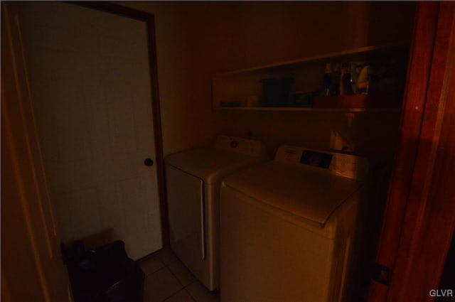 clothes washing area with light tile patterned floors and washer and clothes dryer