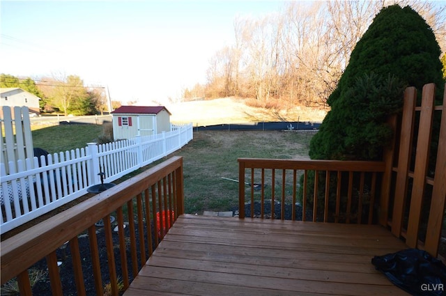 wooden deck featuring a lawn and a storage shed