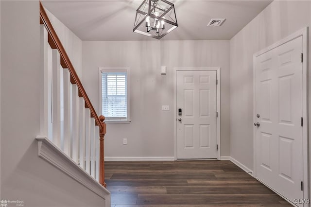 entrance foyer featuring dark wood-type flooring and a notable chandelier