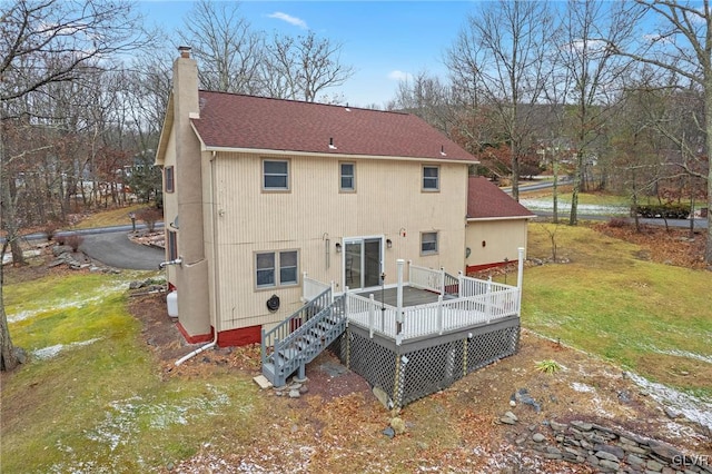 rear view of house featuring a deck and a yard