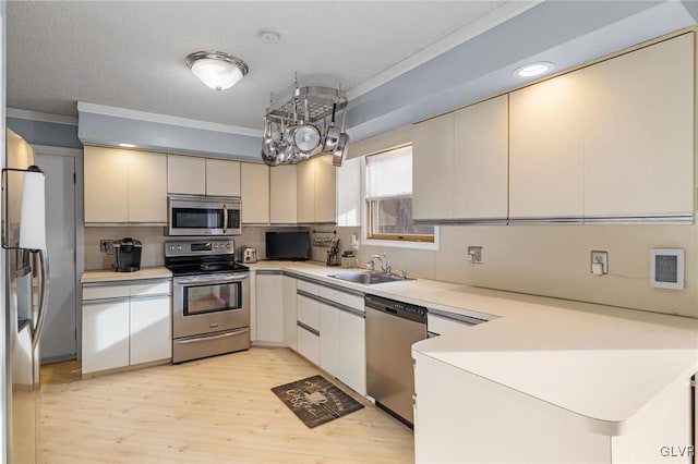 kitchen with sink, light hardwood / wood-style floors, crown molding, and stainless steel appliances