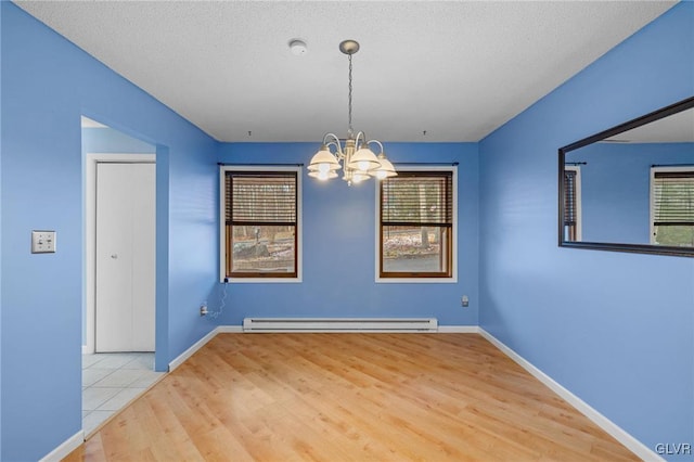 unfurnished dining area with plenty of natural light, an inviting chandelier, wood-type flooring, and a baseboard heating unit