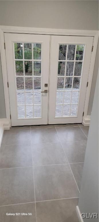 entryway featuring french doors and light tile patterned flooring