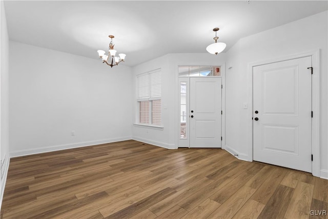 entrance foyer featuring wood-type flooring and an inviting chandelier