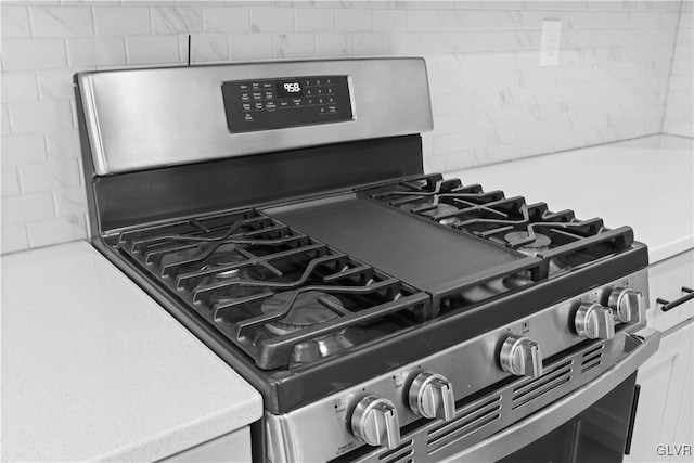 interior details with gas range and white cabinetry