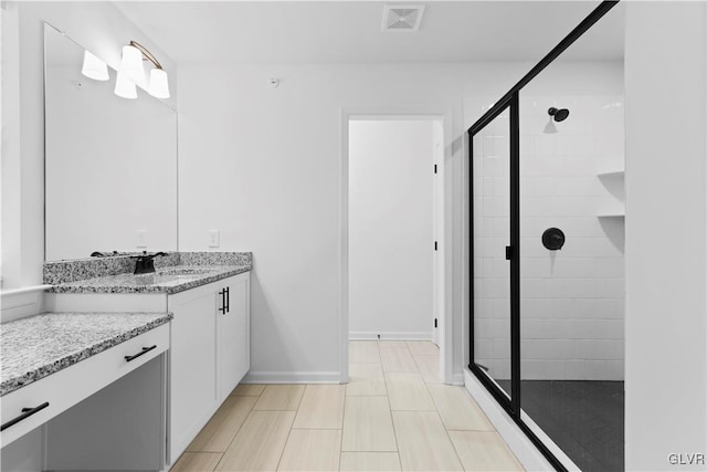 bathroom with vanity and a shower with shower door