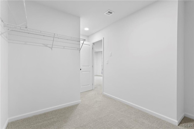 spacious closet with light colored carpet