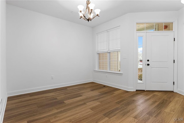 foyer entrance featuring dark wood-type flooring and a notable chandelier