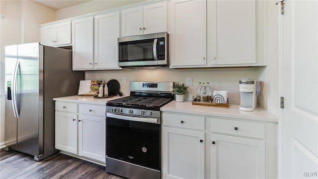 kitchen with dark hardwood / wood-style floors, white cabinetry, and appliances with stainless steel finishes