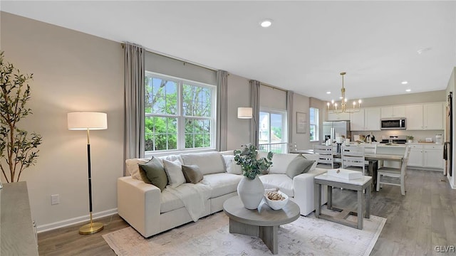 living room with light wood-type flooring and a notable chandelier