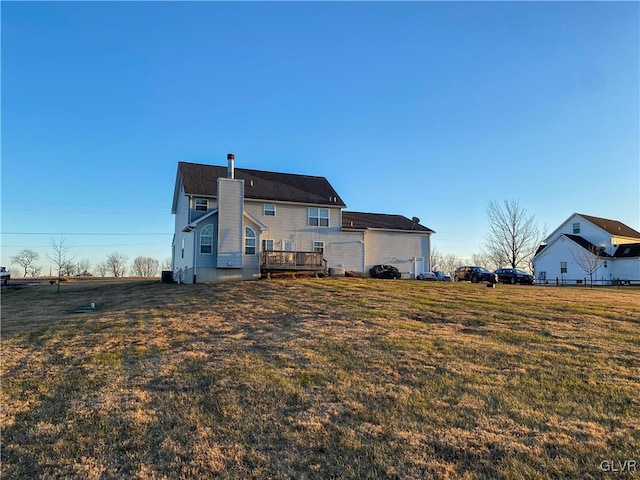 rear view of house with a deck and a yard