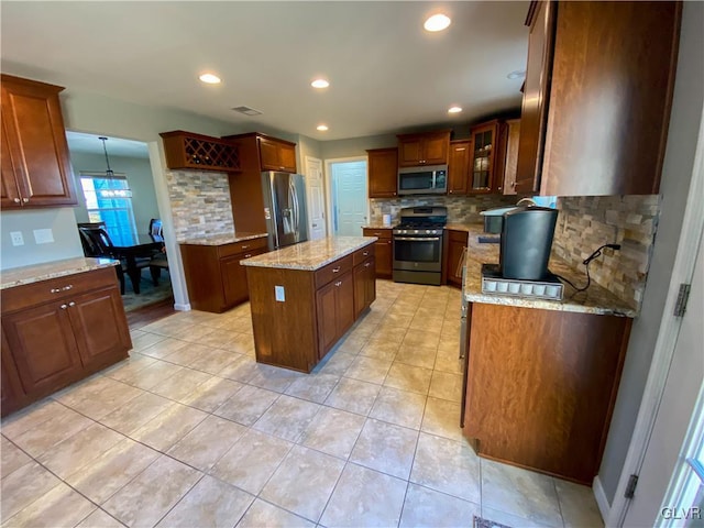 kitchen featuring tasteful backsplash, a kitchen island, recessed lighting, and stainless steel appliances