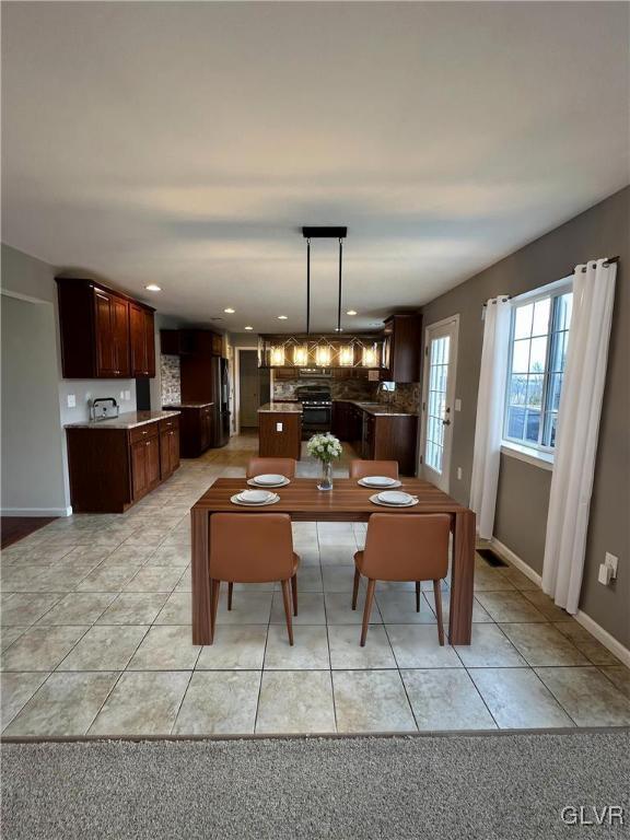 dining space featuring recessed lighting, baseboards, and light tile patterned flooring