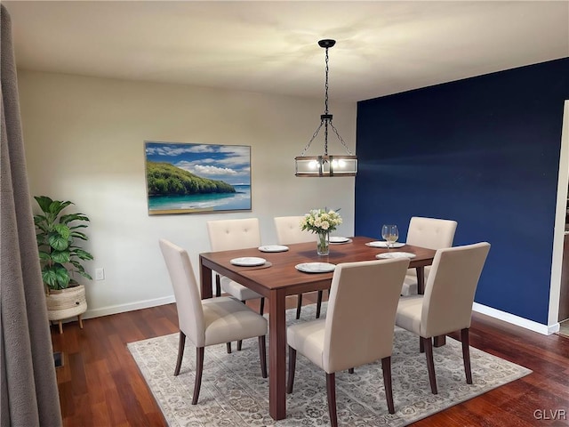 dining space featuring baseboards and wood finished floors