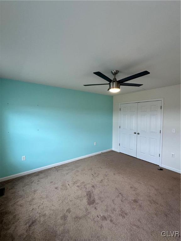 unfurnished bedroom with visible vents, baseboards, ceiling fan, a closet, and carpet flooring