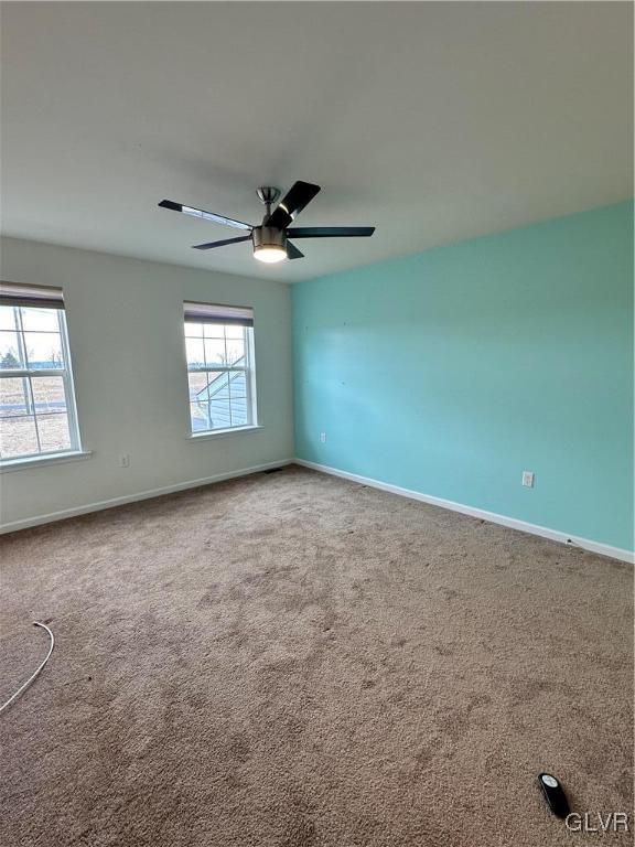 unfurnished room featuring carpet, baseboards, and ceiling fan