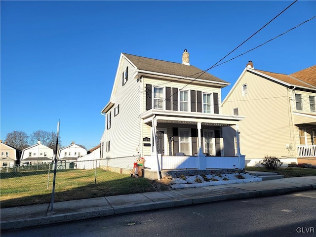 colonial-style house featuring a front lawn and covered porch