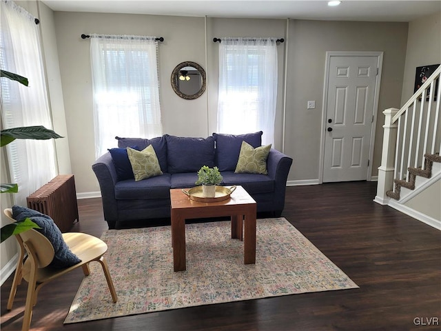 living room featuring radiator heating unit, plenty of natural light, and dark wood-type flooring