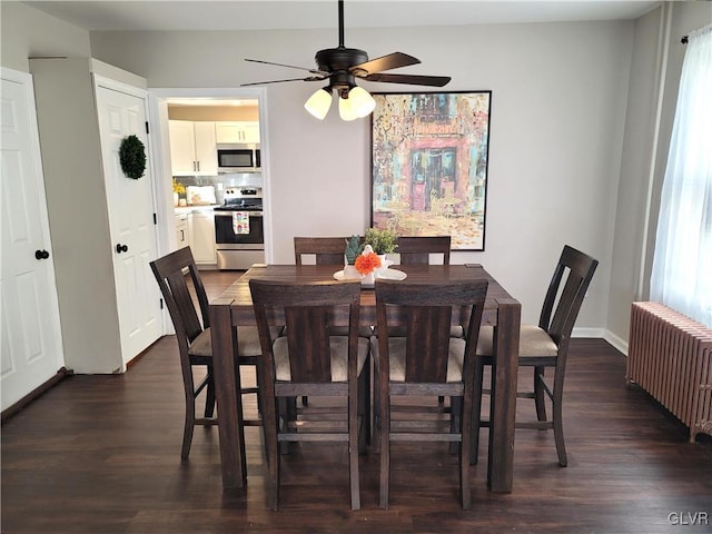 dining area featuring ceiling fan, radiator heating unit, and dark wood-type flooring