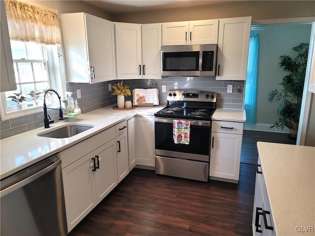 kitchen with white cabinetry, sink, stainless steel appliances, and dark hardwood / wood-style floors