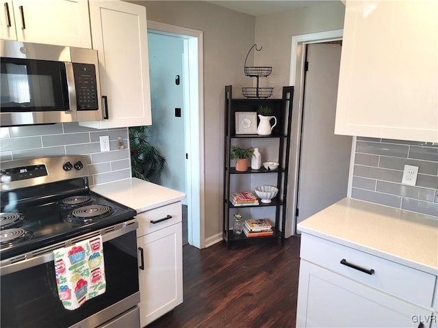 kitchen featuring backsplash, stainless steel appliances, white cabinetry, and dark hardwood / wood-style floors