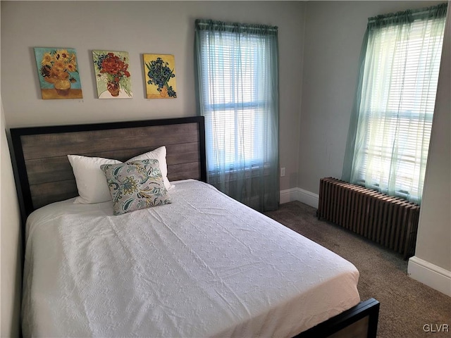 bedroom with radiator, dark carpet, and multiple windows