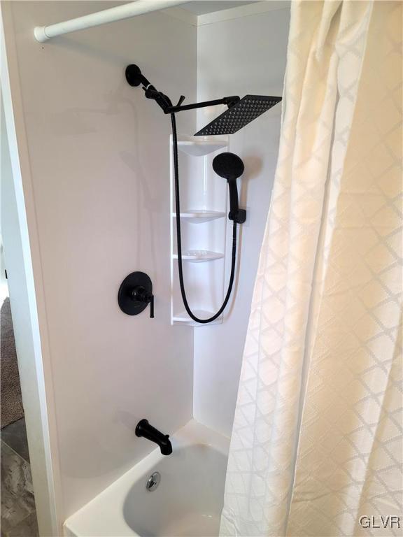 room details featuring shower / bath combo with shower curtain