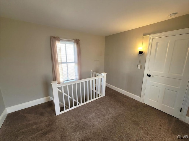 hallway with dark colored carpet