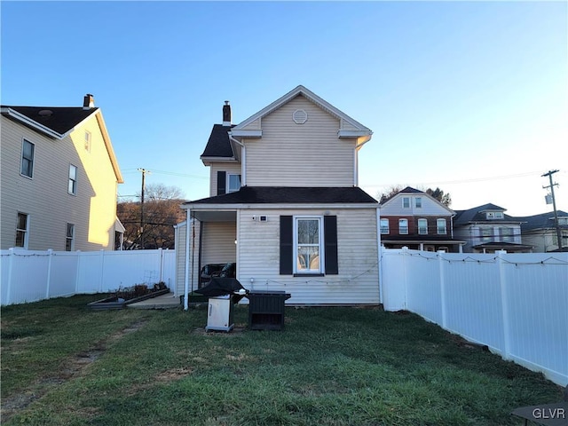 rear view of property featuring a yard