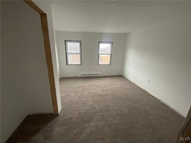 carpeted empty room featuring baseboard heating